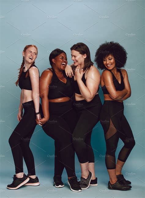 Four Women In Black Sportswear Posing For The Camera With Their Arms