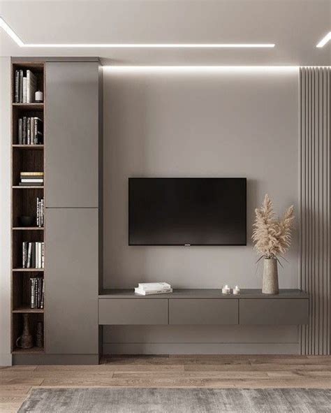 A Living Room With A Large Television On The Wall And Bookshelves In