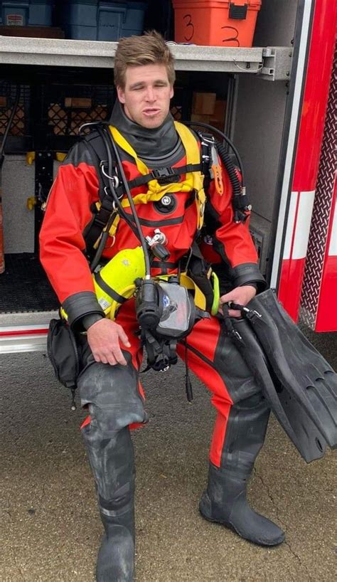 A Fireman Sitting In Front Of A Fire Truck With His Gear And Helmet On