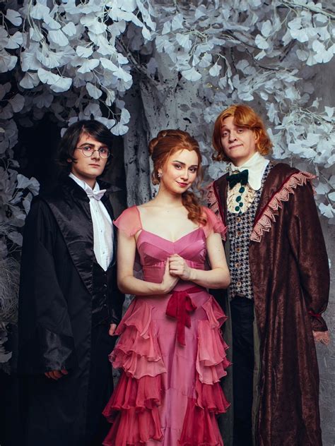 Three Harry Potter cosplayers standing in Yule ball gowns Hermione ...