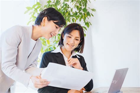 資料を見て相談する2人の女性 ビジネスイメージ 写真素材 [ 7088142 ] フォトライブラリー Photolibrary