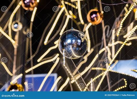 A Merry Christmas Ornaments Hanging In Front Of A Bokeh Background Of