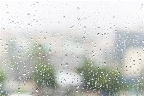 La Lluvia Cae Sobre El Vidrio De La Ventana Con El Fondo Borroso Oscuro