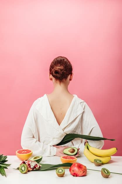 Vista posterior de mujer jengibre con frutas exóticas foto de estudio