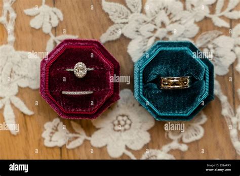 Wedding Rings In Red And Teal Velvet Boxes On A Lace Background Stock