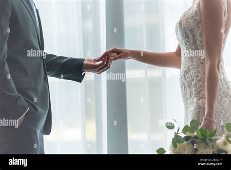 Romantic Groom And Bride Holding Hands Standing By The Window Stock