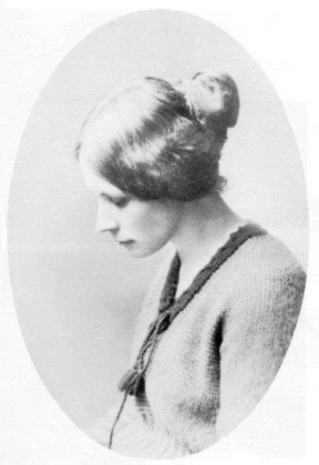 An Old Black And White Photo Of A Woman In A Dress With A High Bun