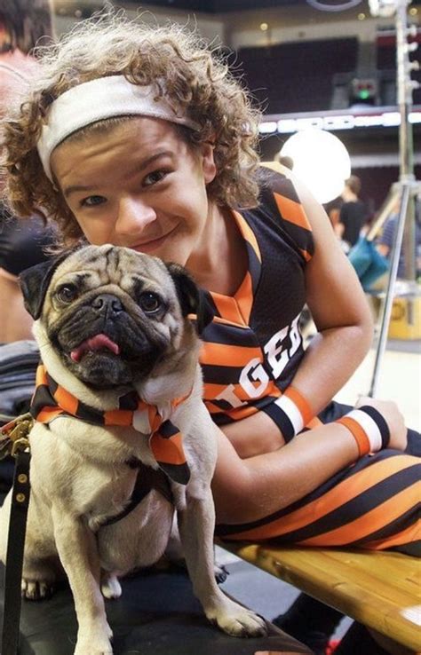 A Woman Sitting On A Bench Holding A Small Pug