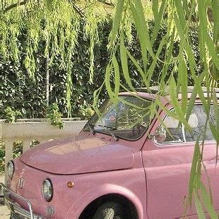 An Old Pink Car Parked Under A Tree