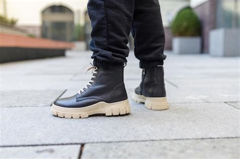 Premium Photo A Man Wearing Black Boots Stands On A Sidewalk Wearing