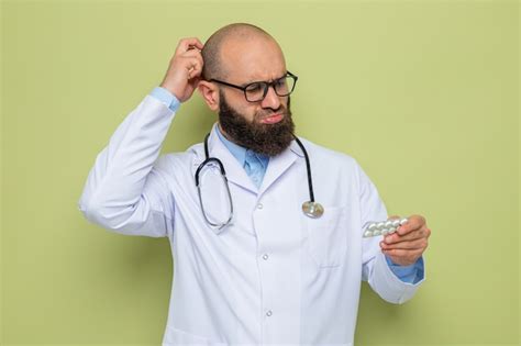 Médico hombre barbudo en bata blanca con estetoscopio alrededor del