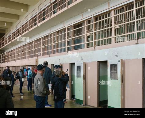 Tourists Inside Alcatraz Federal Penitentiary Looking At Corridors With