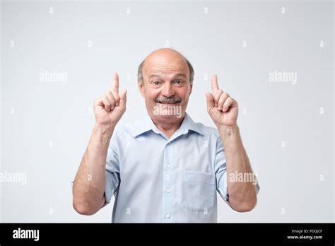Excited Mature Man Pointing Up Over White Background Smiling Senior