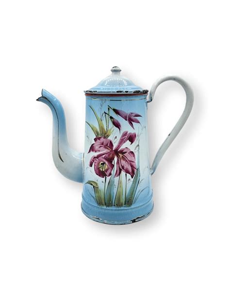 Ancienne cafetière en tôle émaillée blanche à décor floral en relièf