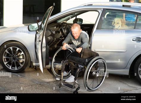Paraplegic Man Assembles His Manual Wheelchair From The Front Seat Of