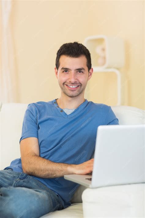 Premium Photo Casual Cheerful Man Sitting On Couch Using Laptop