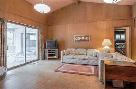 A Living Room With Wood Paneling And Sliding Glass Doors