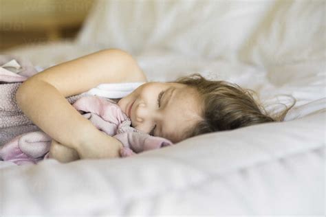 Smiling girl sleeping on bed at home stock photo