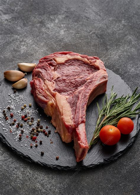 Premium Photo Raw Dry Aged Beef Tomahawk Steak On Slate Board With