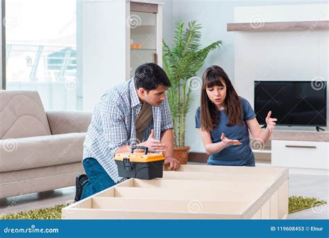 Los Muebles De Junta De La Familia Joven En La Nueva Casa Imagen De