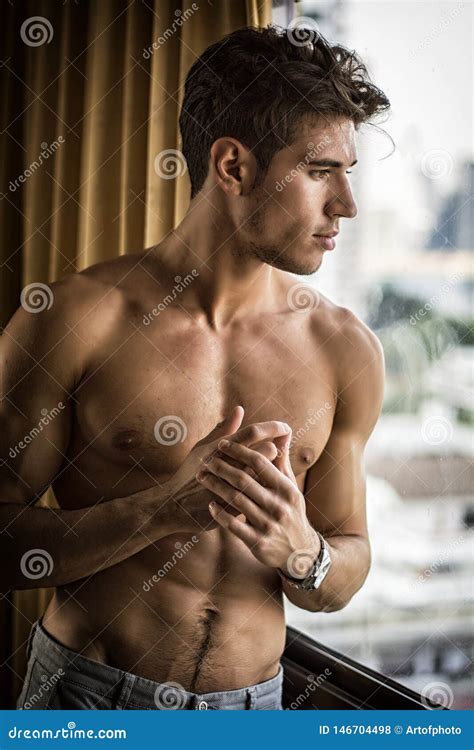 Homem Novo Sexy Que Est Descamisado Por Cortinas Foto De Stock