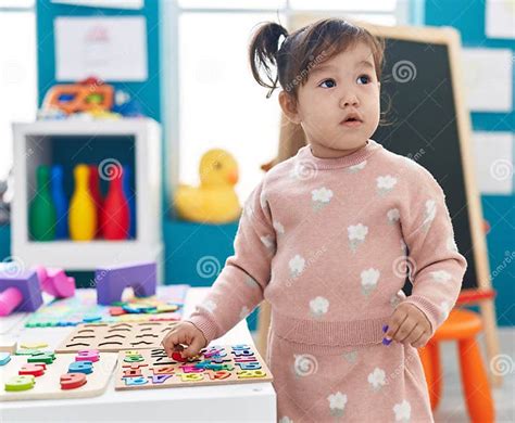 Adorable Chinese Girl Playing With Maths Puzzle Game Standing At