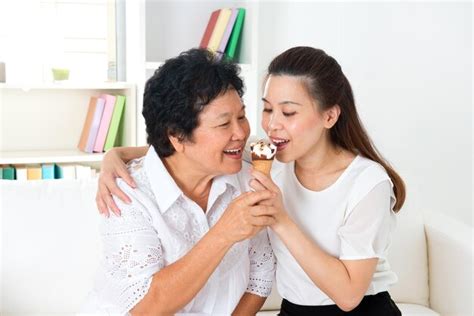 Premium Photo Mother And Daughter Eating Ice Cream Cone While Sitting