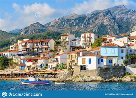 Typical Greek Fishing Boat In Kokkari Bay With Town Houses In