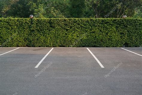 Empty parking lot with foliage wall in the background Stock Photo by ©oppdowngalon 73312647