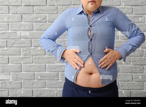 Overweight Boy In Tight Clothes Near Brick Wall Stock Photo Alamy