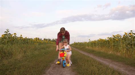 La Maman Enseigne La Fille à Monter Un Vélo Sur Une Route De Campagne