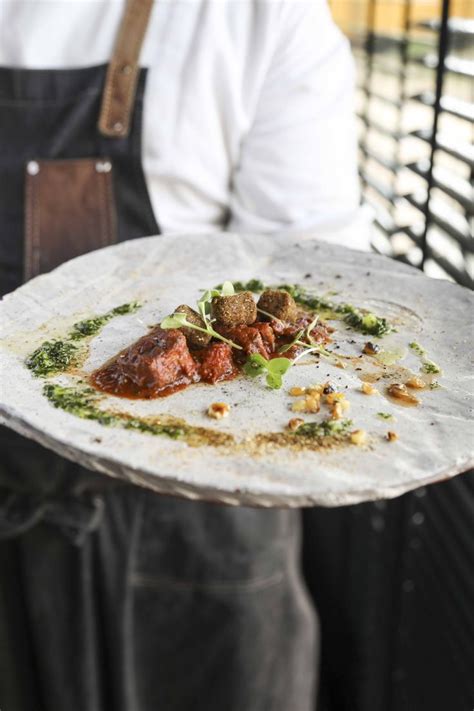 A Person Holding A Plate With Food On It