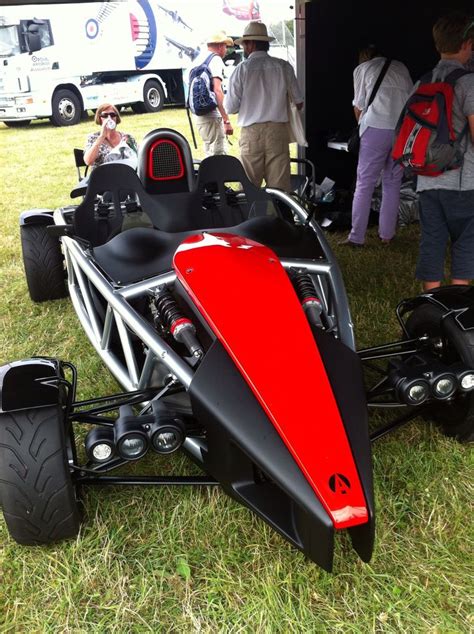 A Red And Black Dune Buggy Parked On Top Of A Grass Covered Field Next