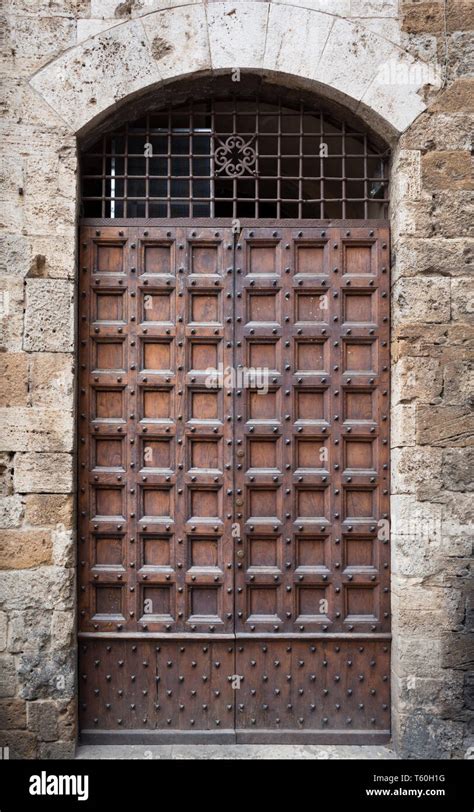 Ancient Wooden Portal With Stone Arch Of An Italian Medieval Building