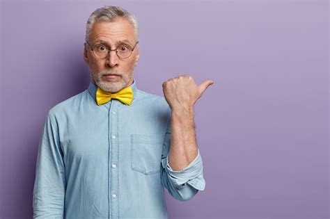 Último homem vestindo camisa azul e gravata borboleta amarela Foto Grátis