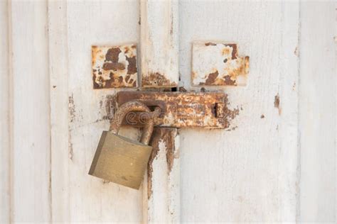 Old And Rusty Metal Padlock On White Doors Closed Door With Lock Stock