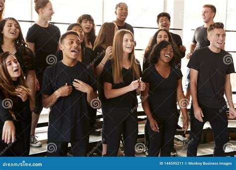 Male And Female Students Singing In Choir At Performing Arts School