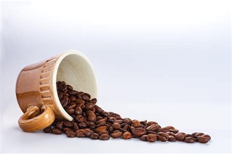 Premium Photo Roasted Coffee Beans Spill Out Of Coffee Mug Overturned