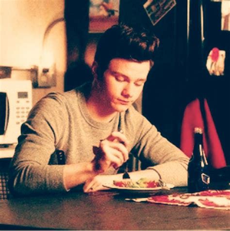 A Man Sitting At A Table Eating Food