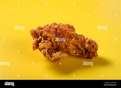 side view fresh deep fried chicken drumstick on yellow background Stock ...