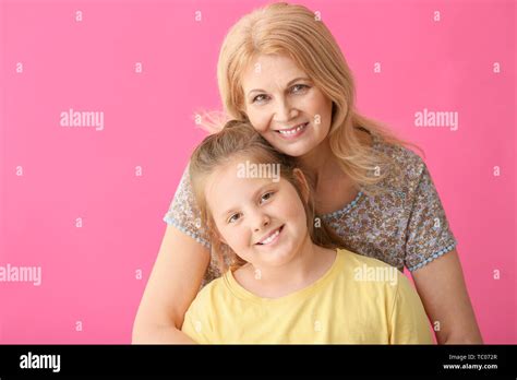Mature Woman And Her Cute Granddaughter On Color Background Stock Photo Alamy