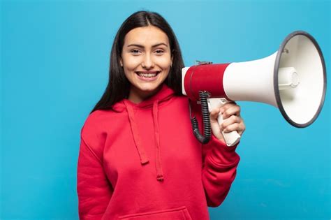 Joven latina que parece feliz y gratamente sorprendida emocionada con una expresión fascinada y