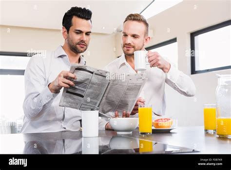 Smiling Gay Couple Reading Newspaper Stock Photo Alamy
