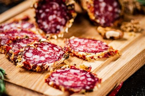 Trozos De Salchicha De Salami En Una Tabla Para Cortar Foto Premium