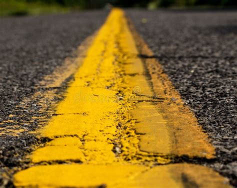 Solid Yellow Line Down a Road with Aged Pavement Stock Image - Image of ...