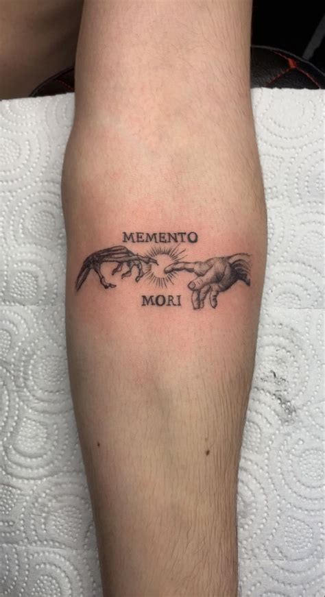 A Tattoo That Reads Mementoo Mori On The Left Arm And An Image Of Two