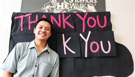 A Man Stands In Front Of A Sign That Says Thank You Premium Ai