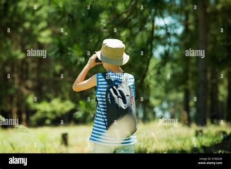 Boy Looking Through Binoculars In Woods Stock Photo Alamy