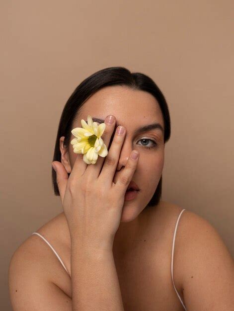 Vue De Face Jeune Femme Posant Avec Une Fleur Photo Gratuite