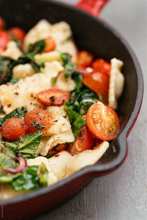 Ravioli With Sauteed Spinach And Cherry Tomatoes By Stocksy